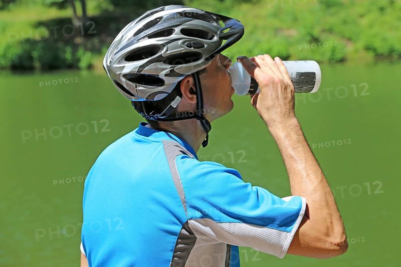 Symbolic image: Mountain biker taking a break at a lake (Edenkoben Valley in the Palatinate Forest)