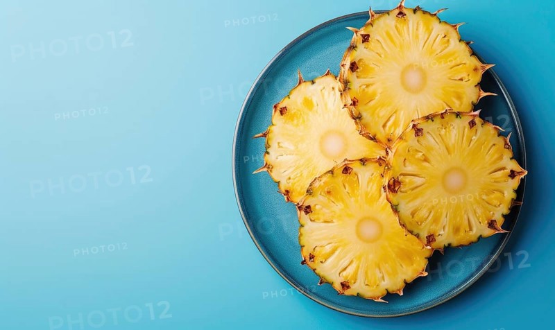 Pineapple slices on blue plate over blue background. Top view with copy space AI generated