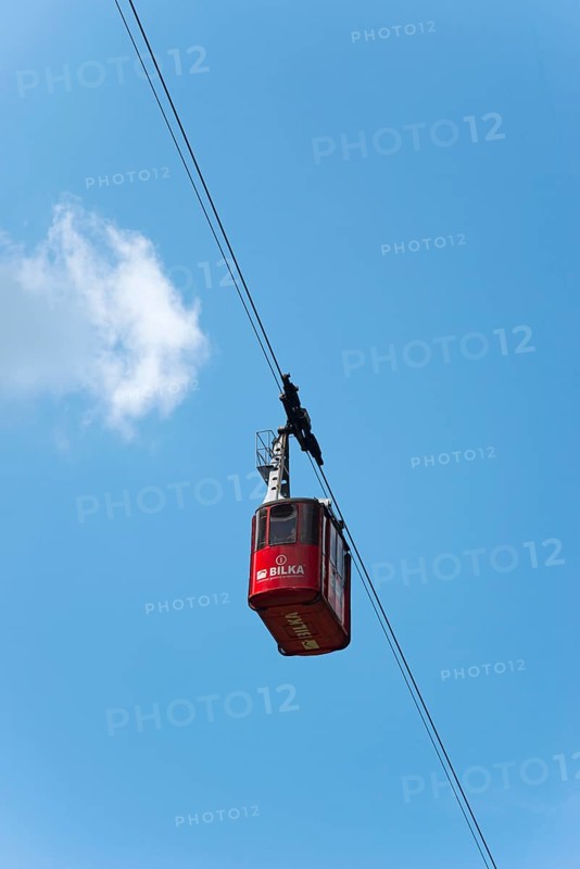 Red cable car gondola hanging on a rope against a clear blue sky with few clouds, Balea Cascada cable car station, Transfogarasan High Road, Transfagarasan, TransfagaraÈ™an, FagaraÈ™ Mountains, Fagaras, Transylvania, Transylvania, Transylvania, Ardeal, Transilvania, Carpathians, Romania, Europe