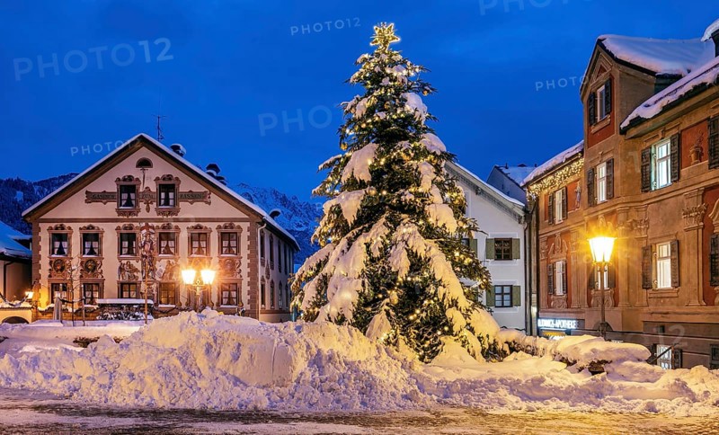 Snow-covered Christmas tree on the historic Ludwigstrasse in the Partenkirchen district at dusk, Garmisch-Partenkirchen, Loisachtal, Werdenfelser Land, Upper Bavaria, Bavaria, Germany, Europe