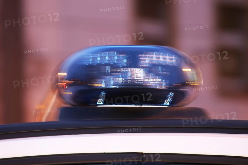 Symbolic image of a police operation: close-up of a flashing blue light on a police car