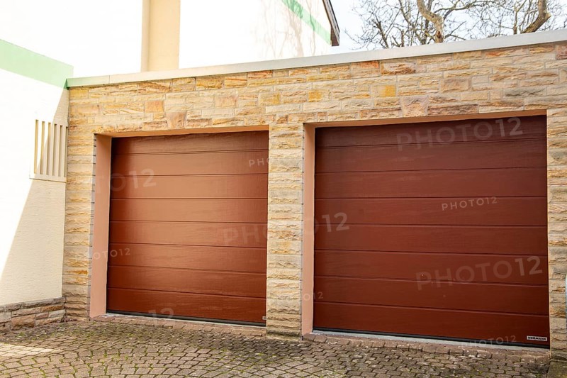 Two red sectional doors from the manufacturer Hoermann on the garage of a detached house