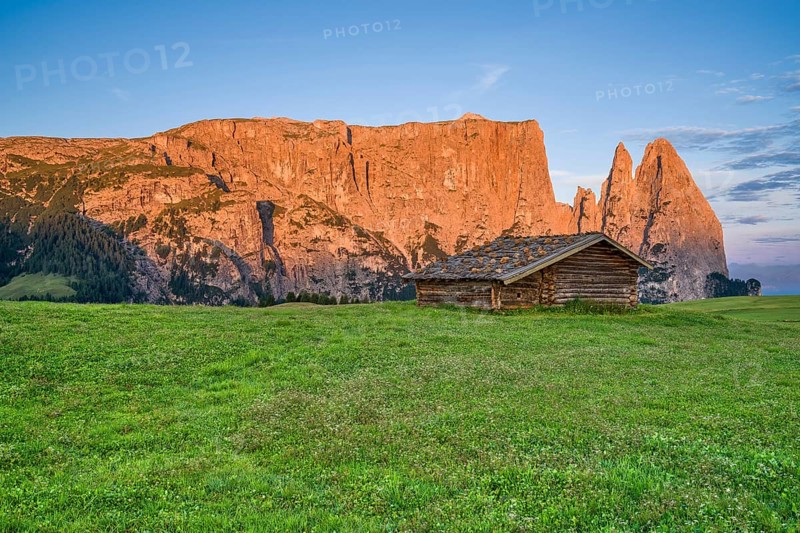 Alpine hut in front of Schlern, sunrise, blue sky with clouds, Seiser Alm, Dolomites, South Tyrol