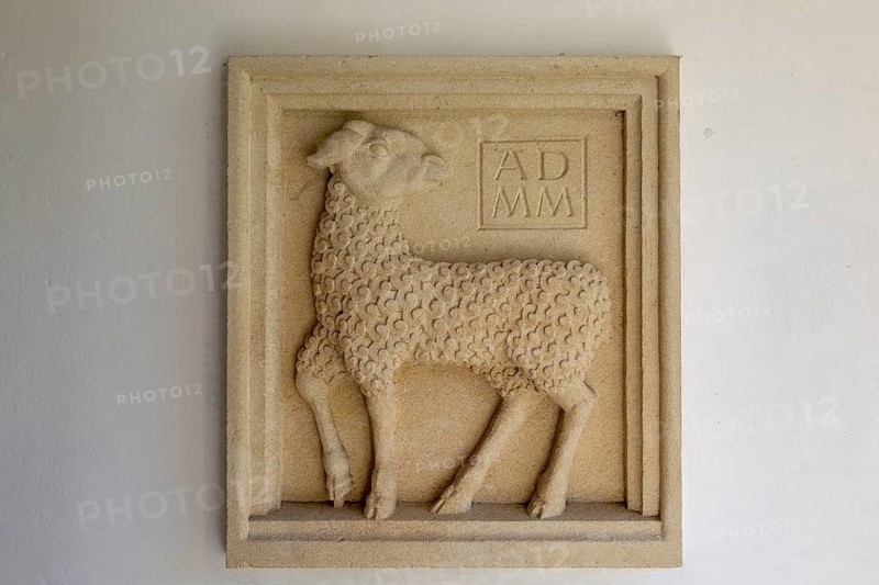 Millennium sculpture Sebastian Brooke carved relief of lamb in porch of Saint John the Baptist church, Mildenhall, Wiltshire, England, UK