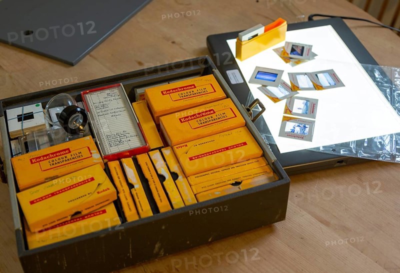 Yellow films storage boxes holding Kodachrome vintage transparency slides dating from 1960s with Lightbox for editing images