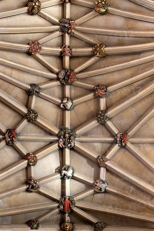 Vaulted stone roof ceiling showing painted roof bosses, Norwich Cathedral, Norfolk, England, UK