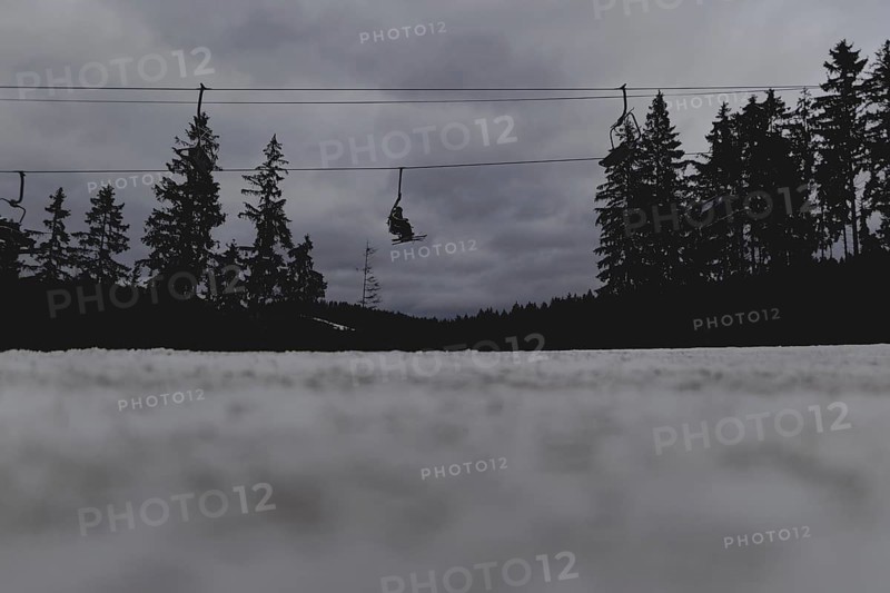 Skiers ride a chairlift, taken on a ski slope in the Jizera Mountains ski area near Albrechtice v Jizerskych Horach, 05.02.2024. The Czech low mountain range with its ski area is affected by increasingly warmer and shorter winters