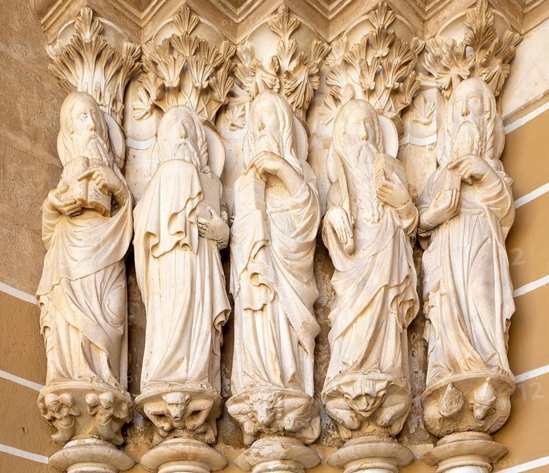 Historic Roman Catholic cathedral church of Evora, Se de Evora, in the city centre, Basilica Cathedral of Our Lady of Assumption. This image shows details of the carved Gothic period Apostles in the main doorway entrance. Marble columns are occupied by huge statues of the Apostles dating from the 1330s