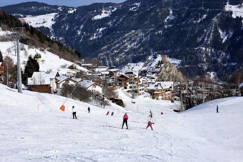 Ladis in winter, the ski piste in the foreground and the village with Laudegg Castle in the background