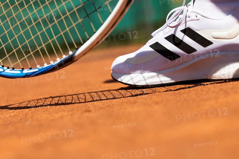Symbolic image of tennis: close-up of a tennis player on a clay court