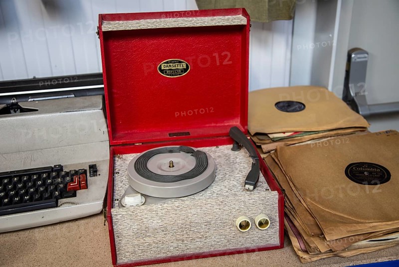A Dansette Popular mono portable record player on sale at auction next to 78 rpm records