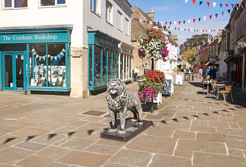 Lion sculpture in historic street and buildings in town centre of Corsham, Wiltshire, England, UK