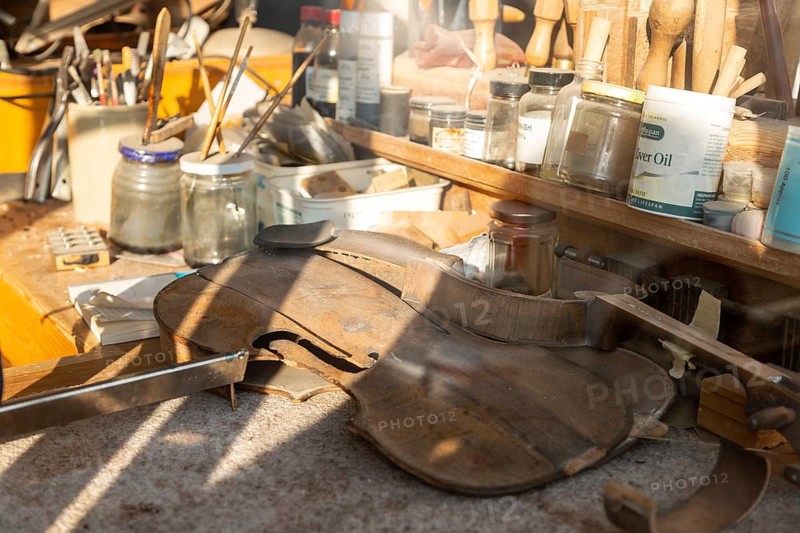 Workbench seen through shop window of the Violin Shop, Market Hill, Woodbridge, Suffolk, England, UK
