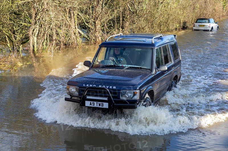 Land Rover Discovery Td5 vehicle driving through flood water at Kellaways, Wiltshire, England, UK 24/12/20