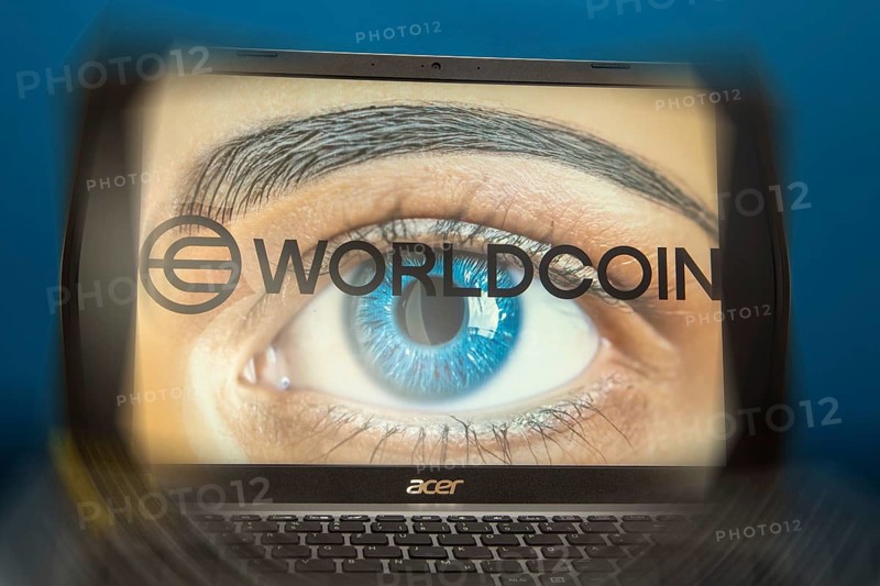 Logo of the new cryptocurrency Worldcoin on a laptop. Anyone wishing to participate in World Coin must register with their biometric data (symbolic image)