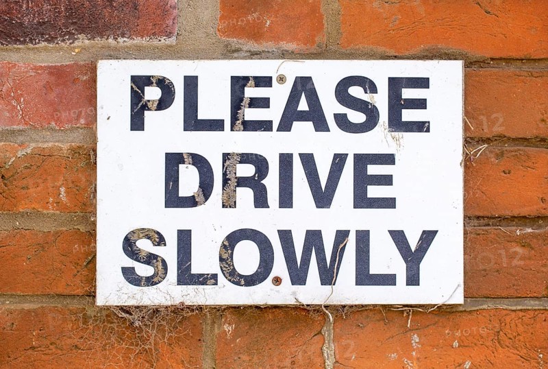 Macro close up sign Please Drive Slowly, UK