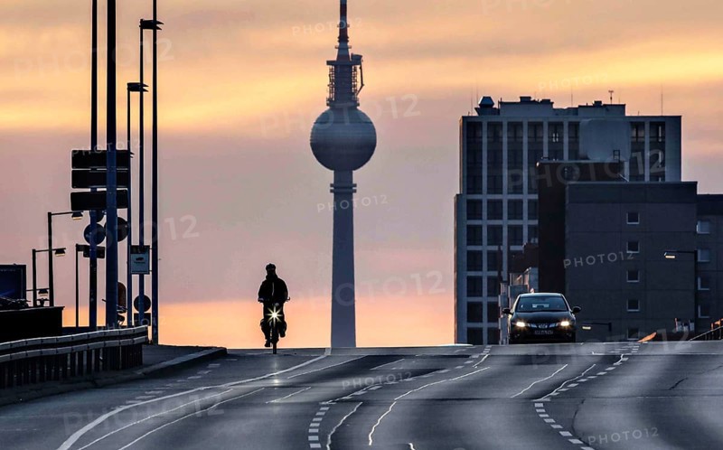 A cyclist and a car driver ride alone on the otherwise busy Frankfurter Allee, Berlin, 29/03/2021