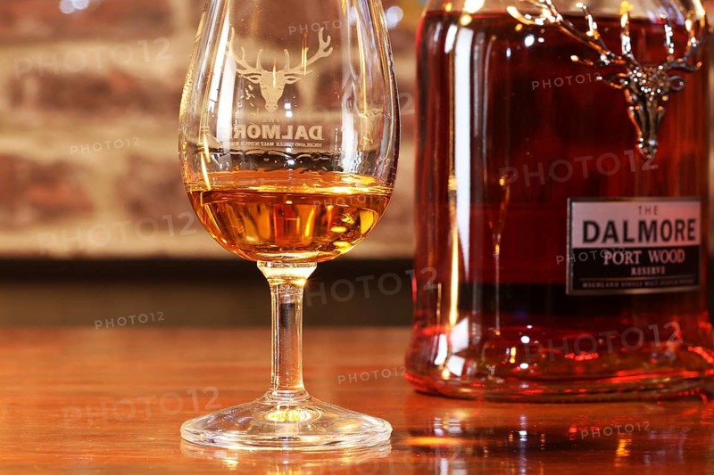 Close-up of a glass of whiskey with a bottle of Dalmore single malt in the background