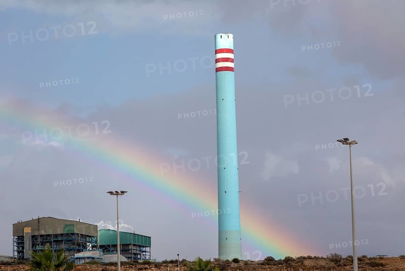 Rainbow in stormy sky behind tall blue industrial cement factory chimney, Carboneras, Almeria, Spain, Europe