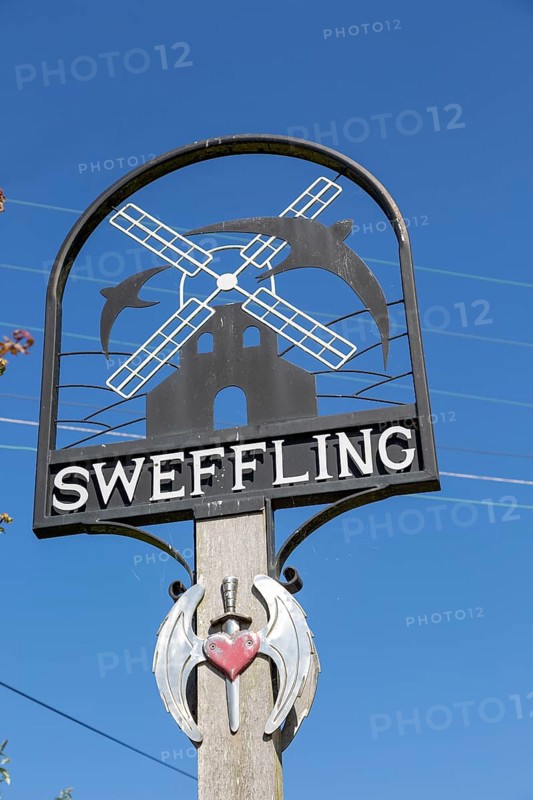 Village sign Sweffling, Suffolk, England, UK with swallow and windmill against blue sky