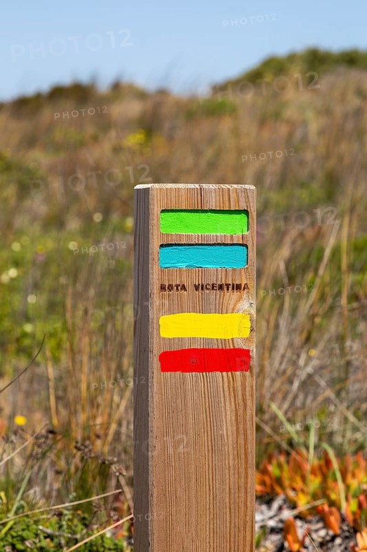 Footpath marker way mark sign painted in green, blue, yellow and red stripes for the Ruta Vicentina long distance footpath, the Fisherman's Trail and Historical Way, within the Southwest Alentejo and Vicentina Coast Natural Park, south west Portugal, southern Europe