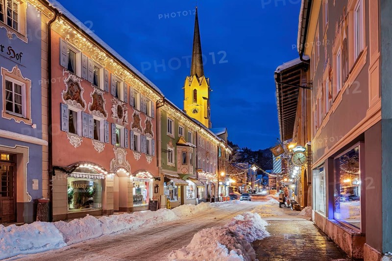 Snow-covered historic Ludwigstrasse in the Partenkirchen district with Christmas lights at dusk, Garmisch-Partenkirchen, Loisachtal, Werdenfelser Land, Upper Bavaria, Bavaria, Germany, Europe