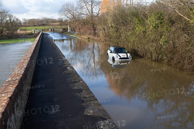 Mini Cooper S car stuck in River Avon flood water, Kellaways bridge, Wiltshire, England, UK 24/12/20