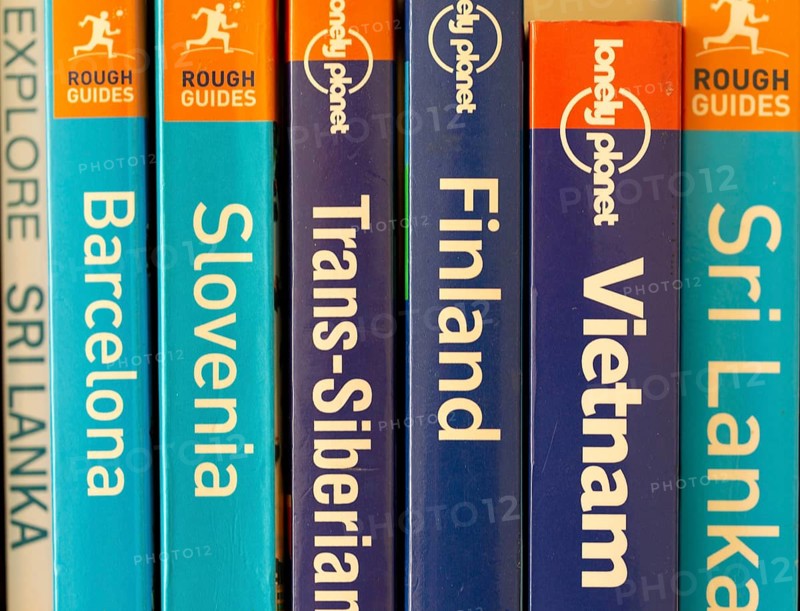 Close up of various travel guide books published by Lonely Planet and Rough Guides