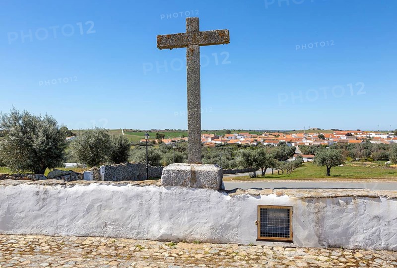View of buildings rural country village from church Igreja Santa Barbara de Padroes, near Castro Verde, Baixo Alentejo, Portugal, southern Europe overlooking olive trees and standing stone cross, Europe