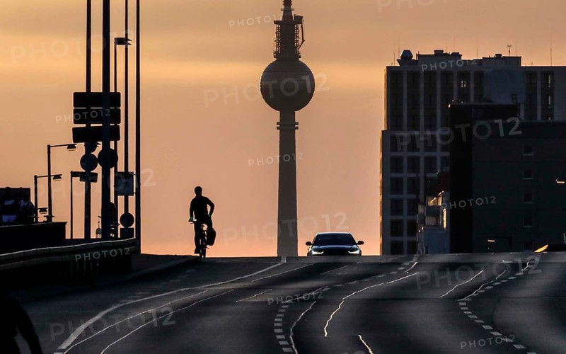 A cyclist and a car driver ride alone on the otherwise busy Frankfurter Allee, Berlin, 29/03/2021