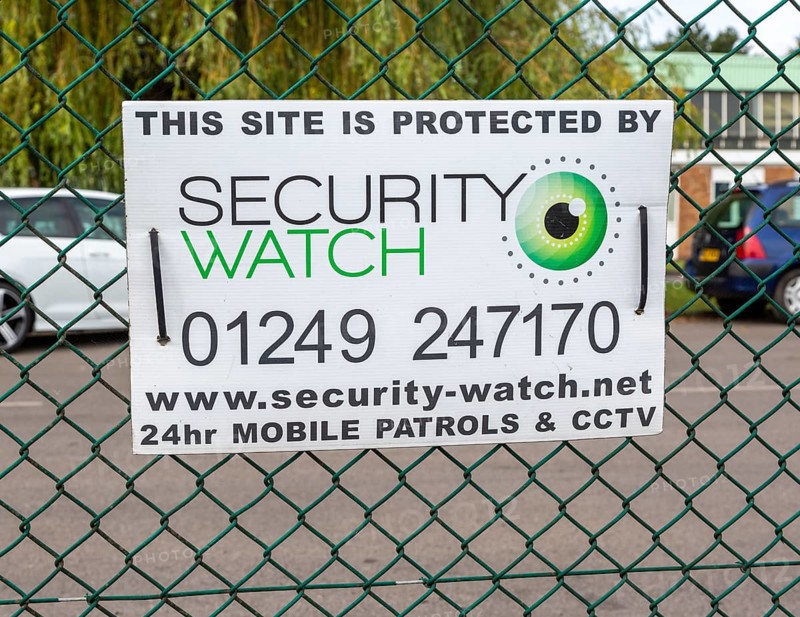Security protection sign on wire fence, Porte Marsh Industrial Estate, Calne, Wiltshire, England, UK