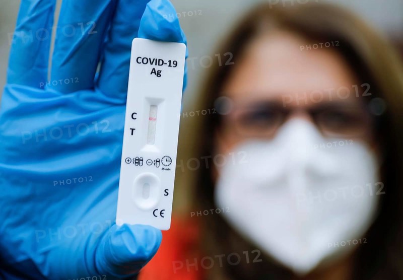A woman with FFP2 mask shows a negative Corona rapid test, Berlin, 11.03.2021