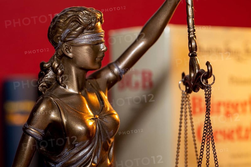 Symbolic image of jurisdiction: Justitia with the BGB (German Civil Code) in the background