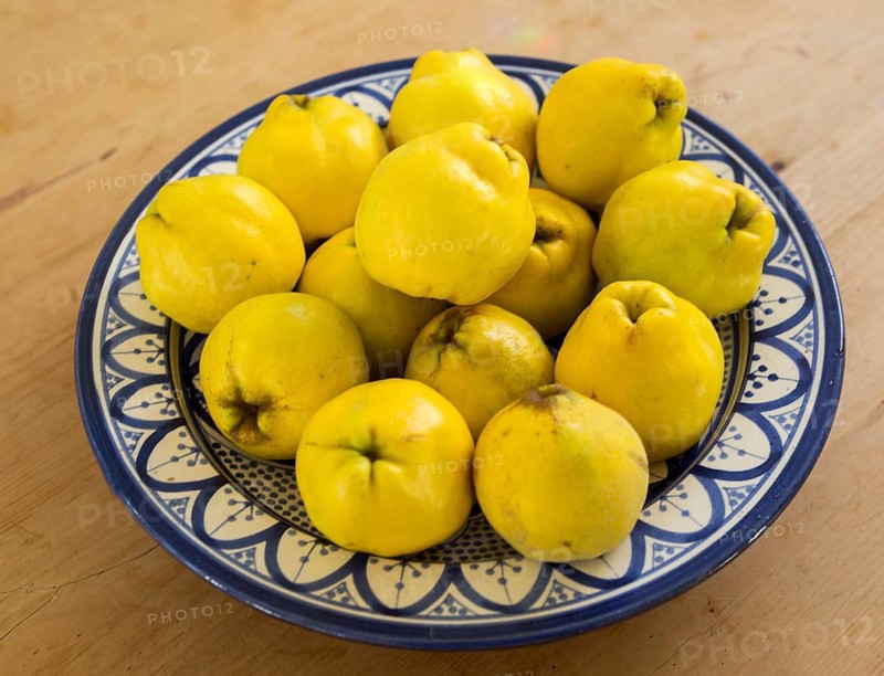 Close up bowl dish of fresh quince fruit on kitchen table, UK