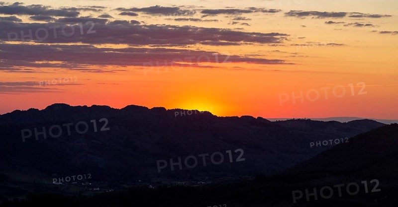Sunset with glowing sky orange sun dropping behind hills. Photo taken looking south west from Marvao, Portalegre district, Alto Alentejo, Portugal, Southern Europe, Europe