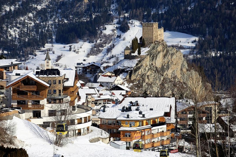 Ladis in winter, the ski piste in the foreground and the village with Laudegg Castle in the background