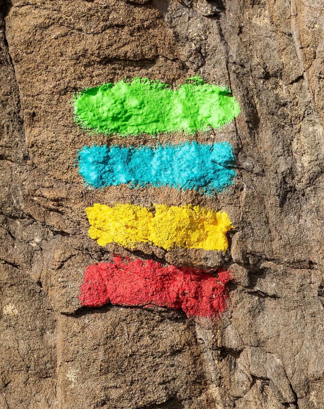 Footpath marker way mark sign painted in green, blue, yellow and red stripes for the Ruta Vicentina long distance footpath, the Fisherman's Trail and Historical Way, within the Southwest Alentejo and Vicentina Coast Natural Park, south west Portugal, southern Europe