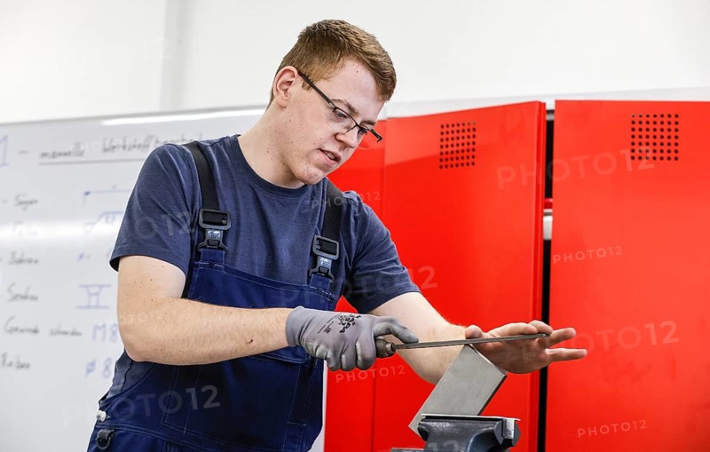 A trainee mechatronics technician works on a workpiece at a Deutsche Bahn training centre, Berlin, 07/02/2024