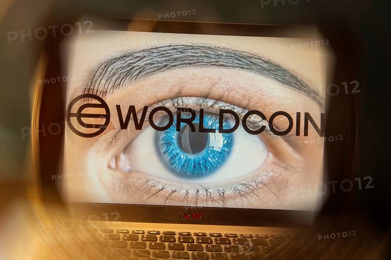 Logo of the new cryptocurrency Worldcoin on a laptop. Anyone wishing to participate in World Coin must register with their biometric data (symbolic image)
