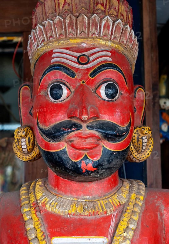 A close-up of a traditional red-faced statue of a man with a mustache, Matancherry, Jew Town, Cochin, Kerala, India, Asia