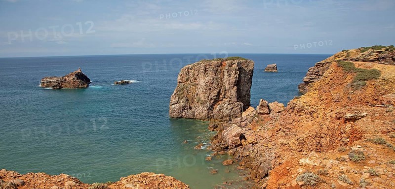 Coastal stacks and stumps orange coloured crumbling cliffs rise from Atlantic Ocean at Cabo de Sao Vicente, Cape St Vincent, Algarve, Portugal, southern Europe, Europe