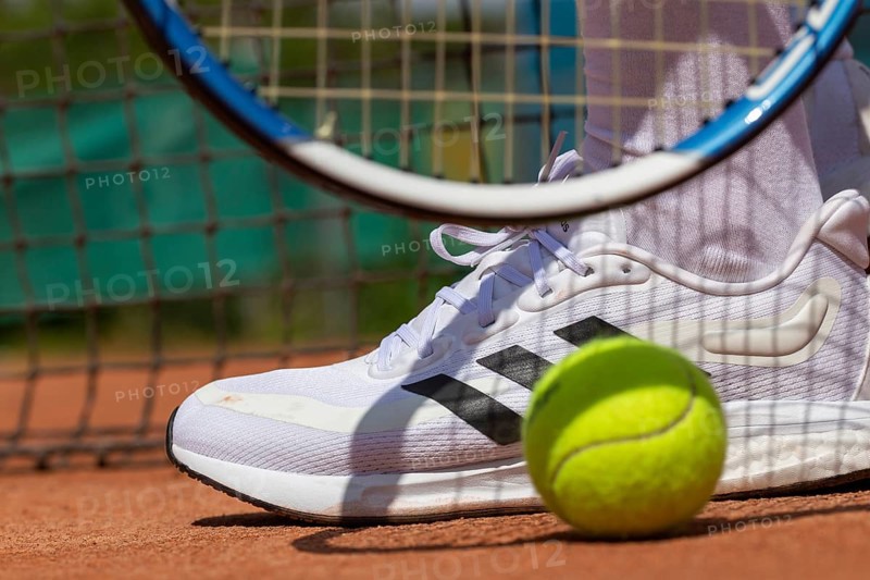 Symbolic image of tennis: close-up of a tennis player on a clay court