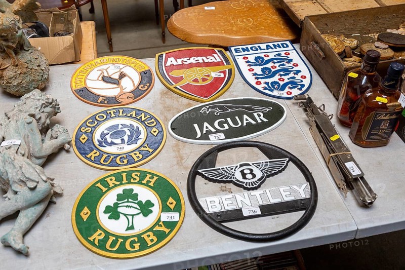 Replica cast iron metal plaques on table at auction, England, UK