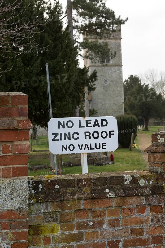 No Lead Zinc Roof No Value sign outside church to deter potential thieves who target churches for their lead roofs, Ellingham, Norfolk, England, UK