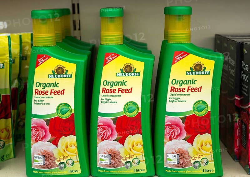 Plastic containers of Neudorff Organic Rose Feed liquid concentrate on shelf display in garden centre, UK