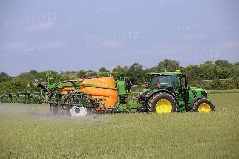 A farmer from the Schmitt vegetable farm in Hockenheim drives his tractor with a crop protection sprayer over his wheat field to combat brown rust and mildew (Hockenheim, Baden-Wuerttemberg)