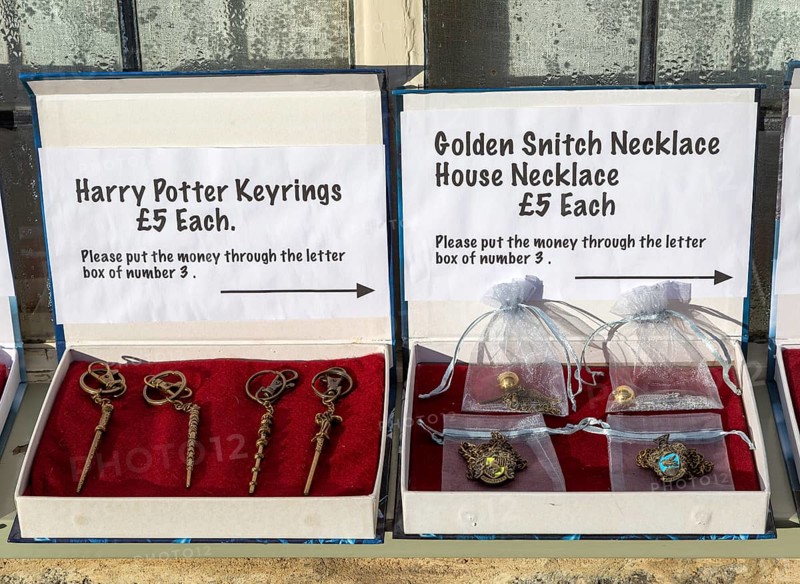 Display boxes Harry Potter souvenir products on sale on trust outside house, Lacock, Wiltshire, England, UK