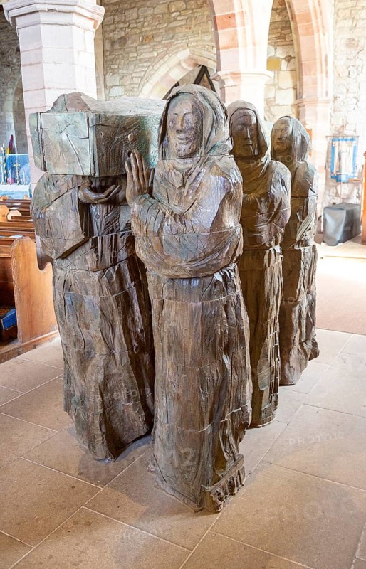 The Journey Sculpture of monks carrying body of Saint Cuthbert by Fenwick Lawson 1999 Holy Island, Northumberland, England, UK