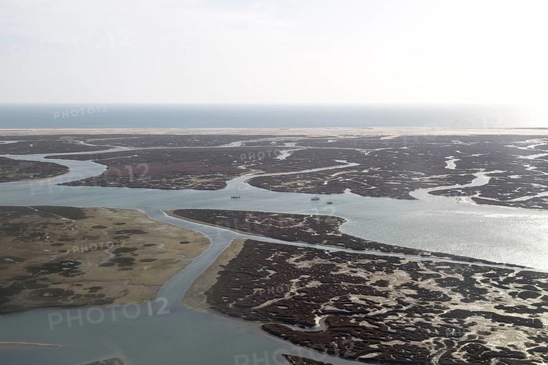 Coastal landscape of salt marsh and drainage channels along the coastline off Faro, Algarve, Portugal, Europe