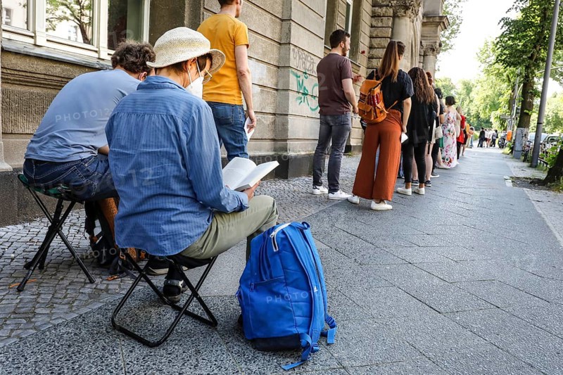 Vaccinated people in a queue sitting on folding chairs. Neighbourhood residents in the Tempelhof Schoeneberg district can get vaccinated free of charge and without registering here, Berlin, 05.06.2021